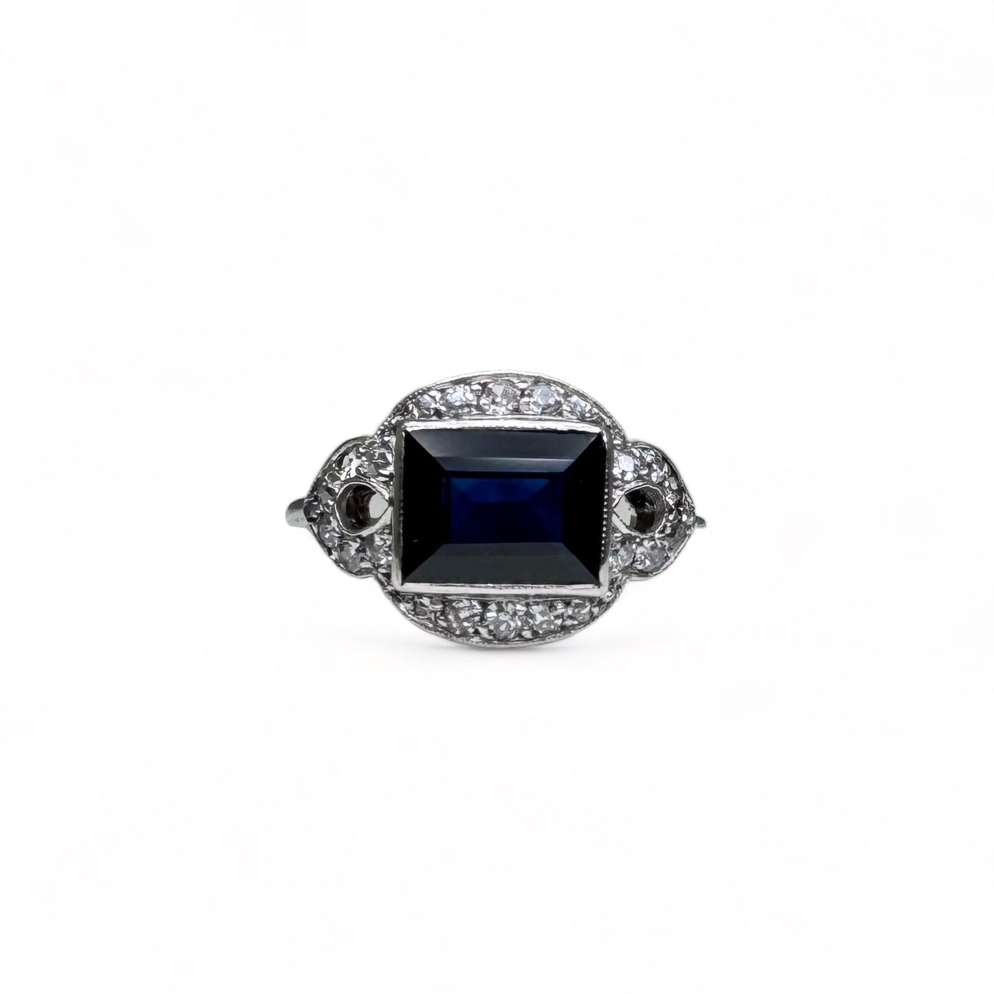 Bague Art-Deco en platine centrée d’un saphir dans un entourage de diamants.