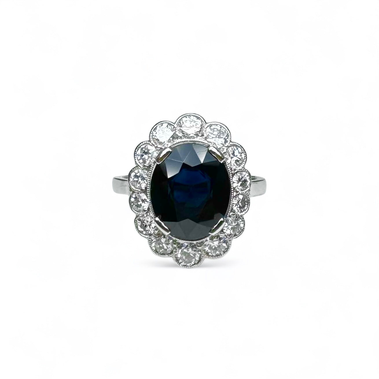 Bague marguerite en platine centrée d’un saphir entouré de diamants.