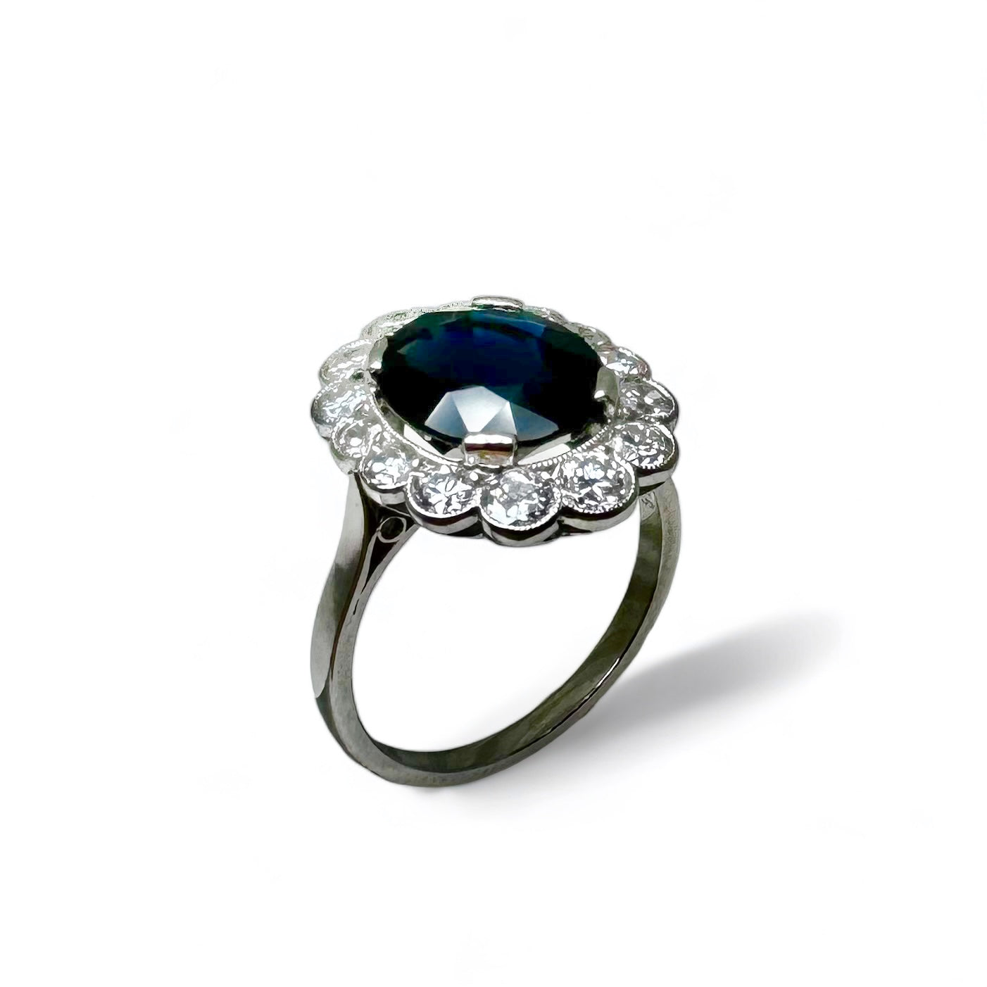 Bague marguerite en platine centrée d’un saphir entouré de diamants.