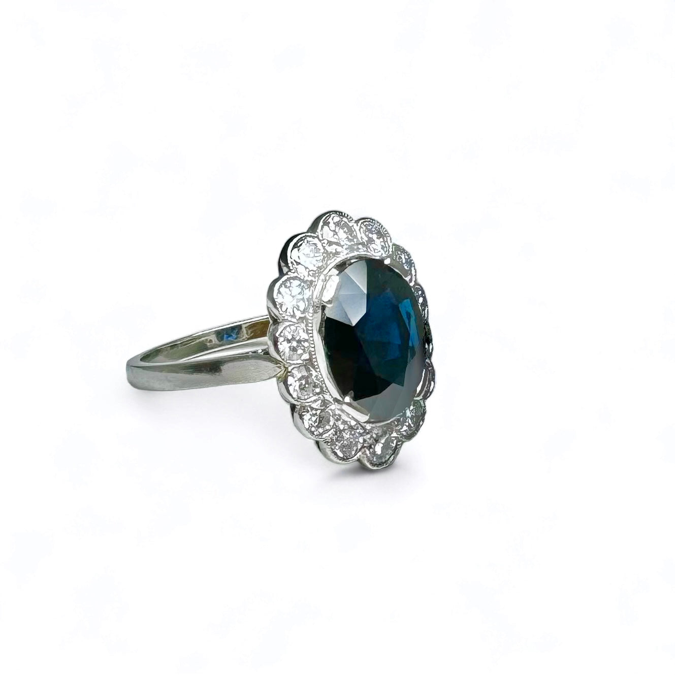 Bague marguerite en platine centrée d’un saphir entouré de diamants.