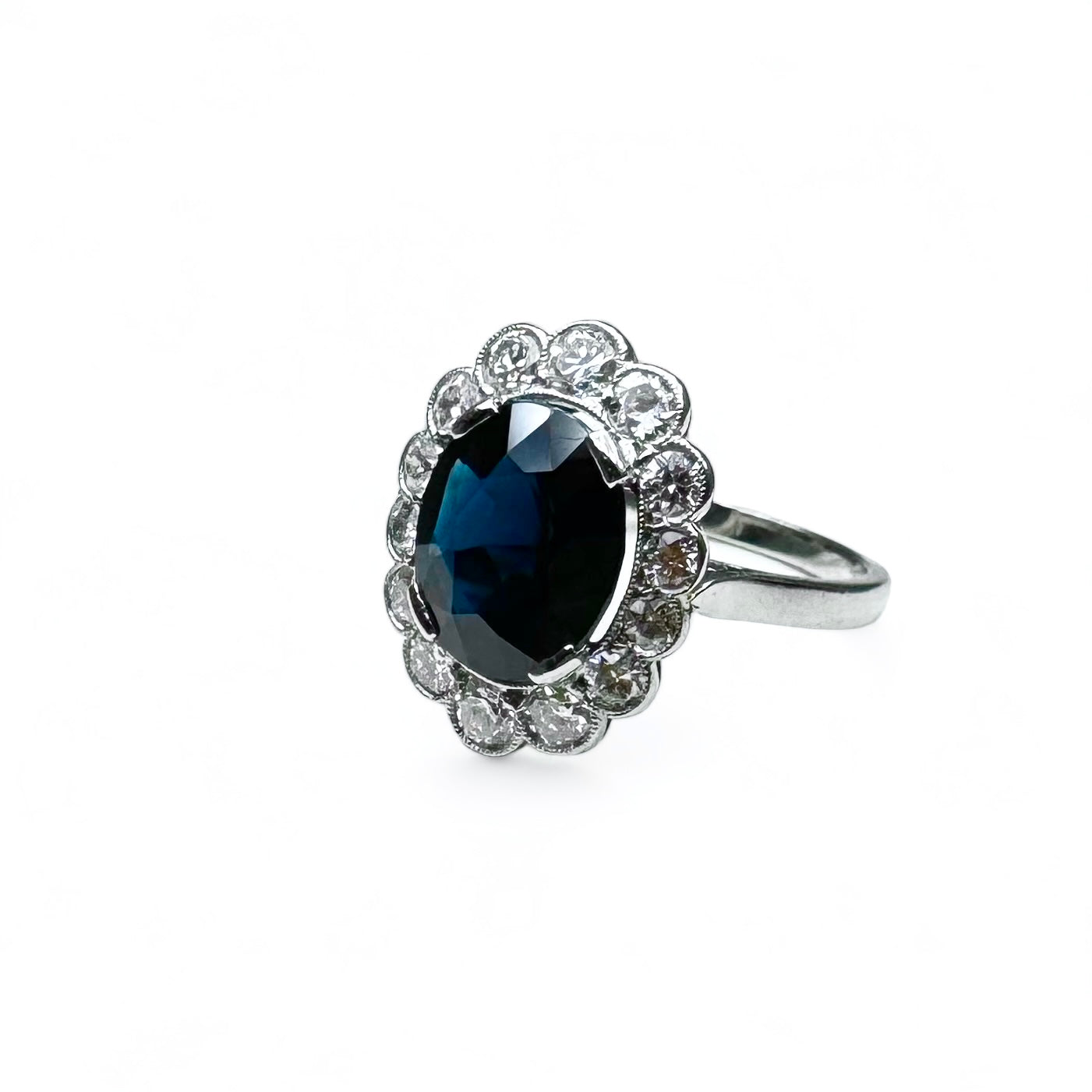 Bague marguerite en platine centrée d’un saphir entouré de diamants.