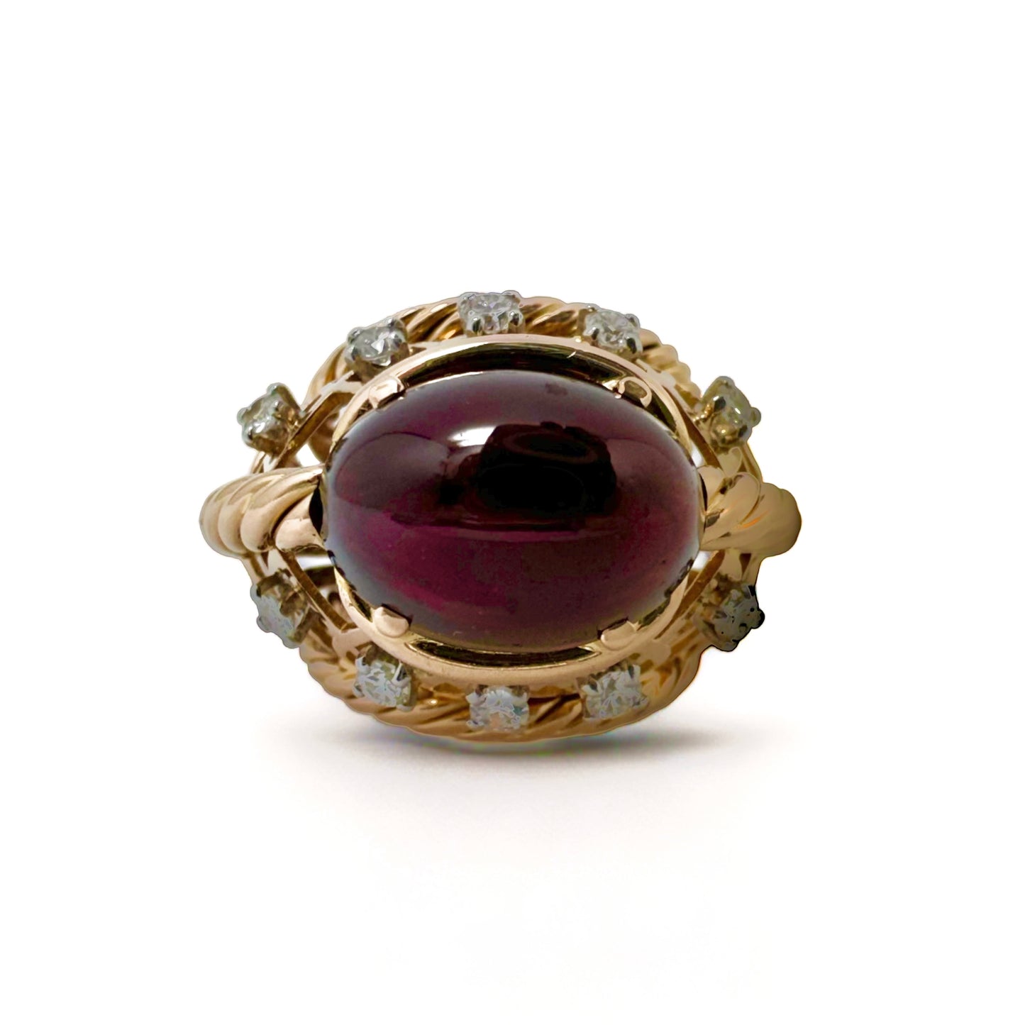 Bague dôme en or jaune ornée d’un grenat entouré de diamants.