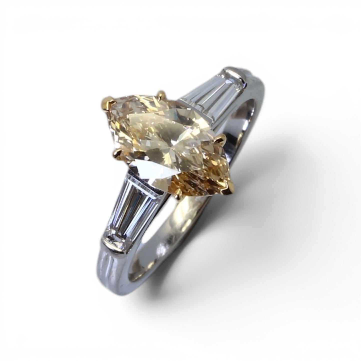 Bague solitaire ornée d’un diamant taille navette et de diamants baguettes.