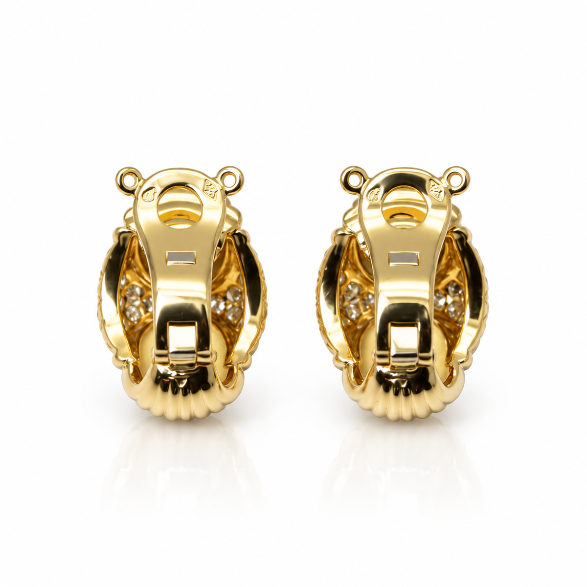 Boucles d’oreille en or jaune pavées de diamants.