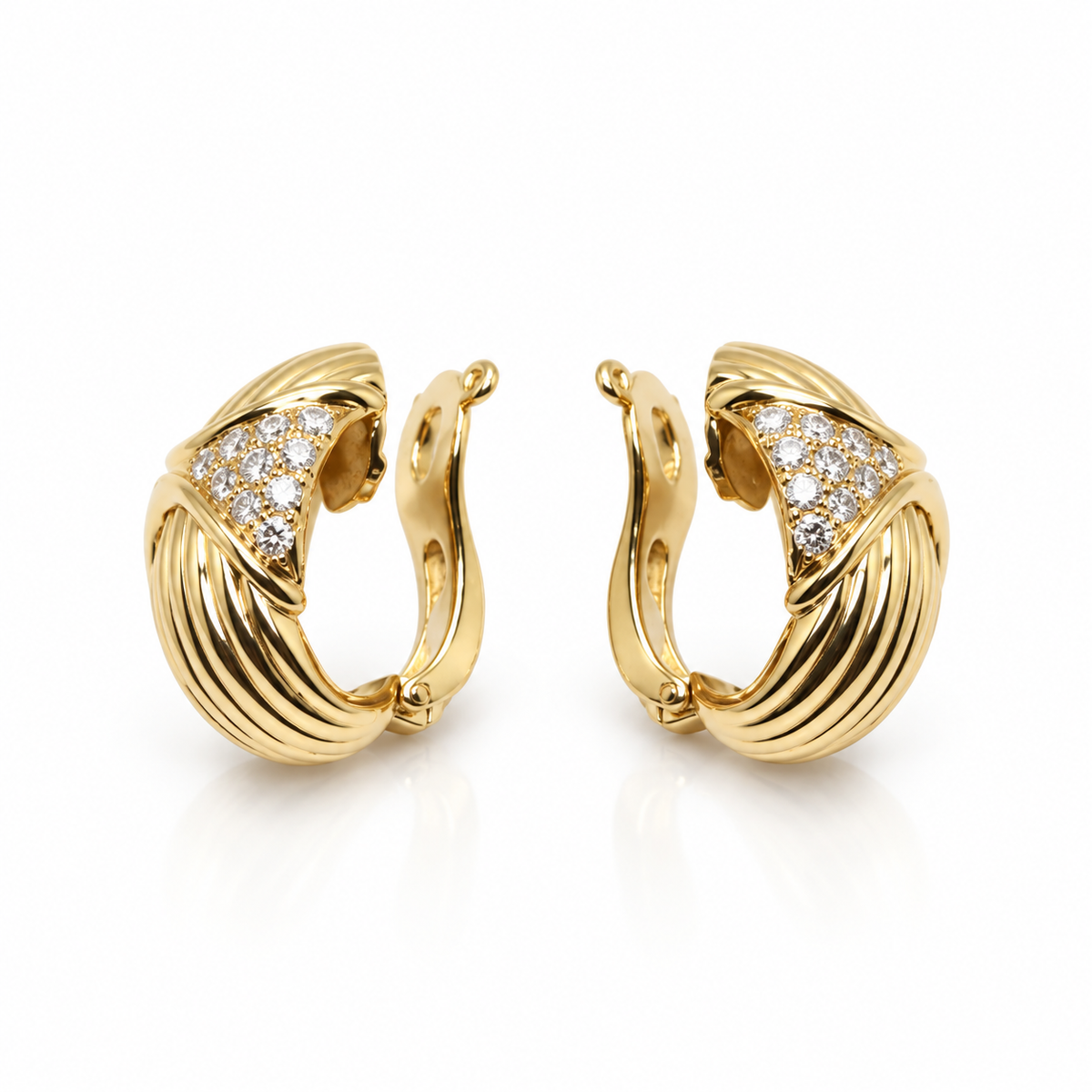 Boucles d’oreille en or jaune pavées de diamants.