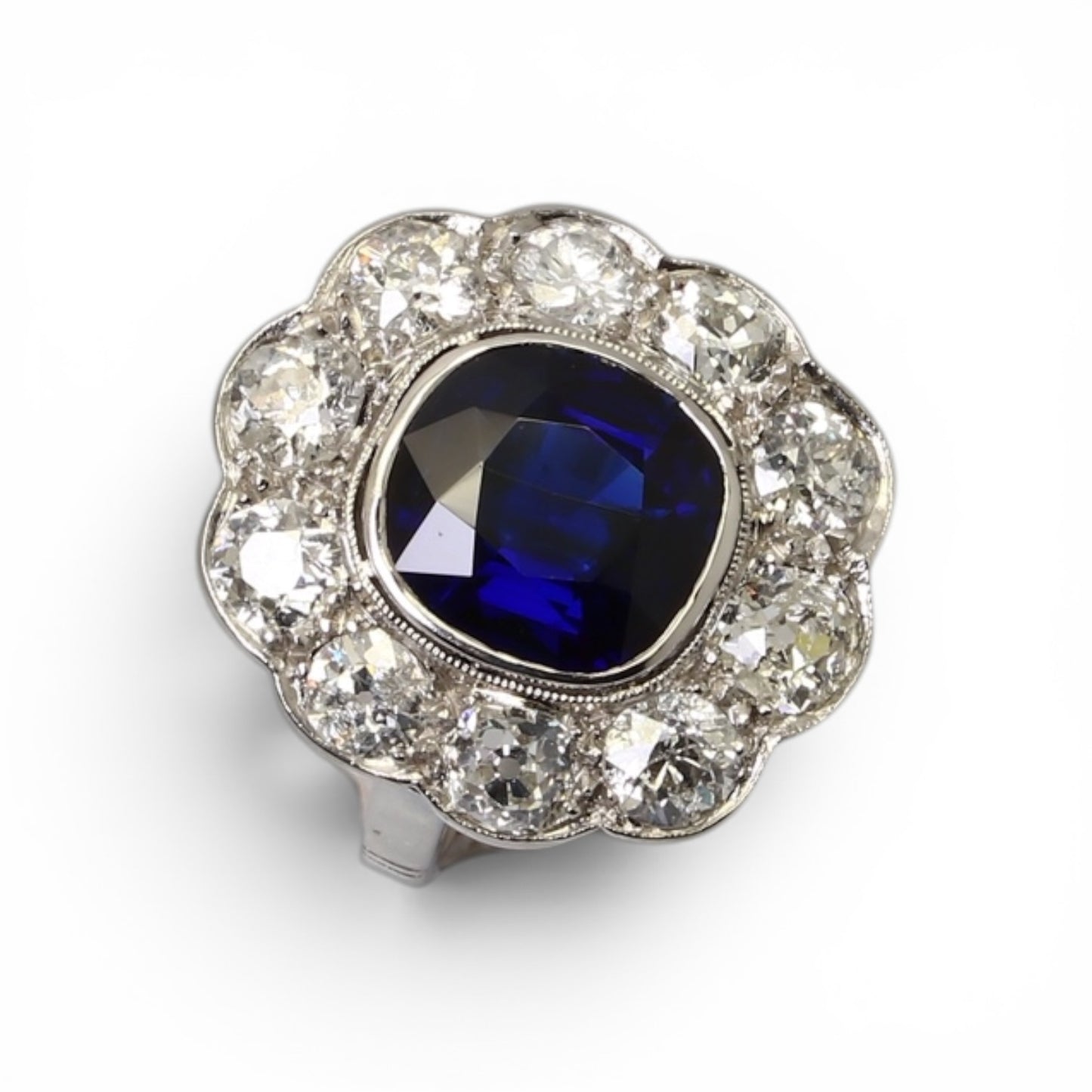 Bague « Marguerite » en platine ornée d’un saphir entouré de diamants taille ancienne.