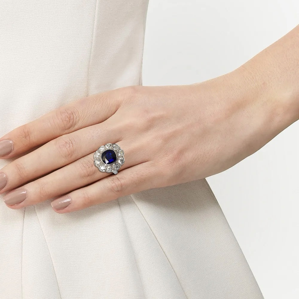 Bague « Marguerite » en platine ornée d’un saphir entouré de diamants taille ancienne.