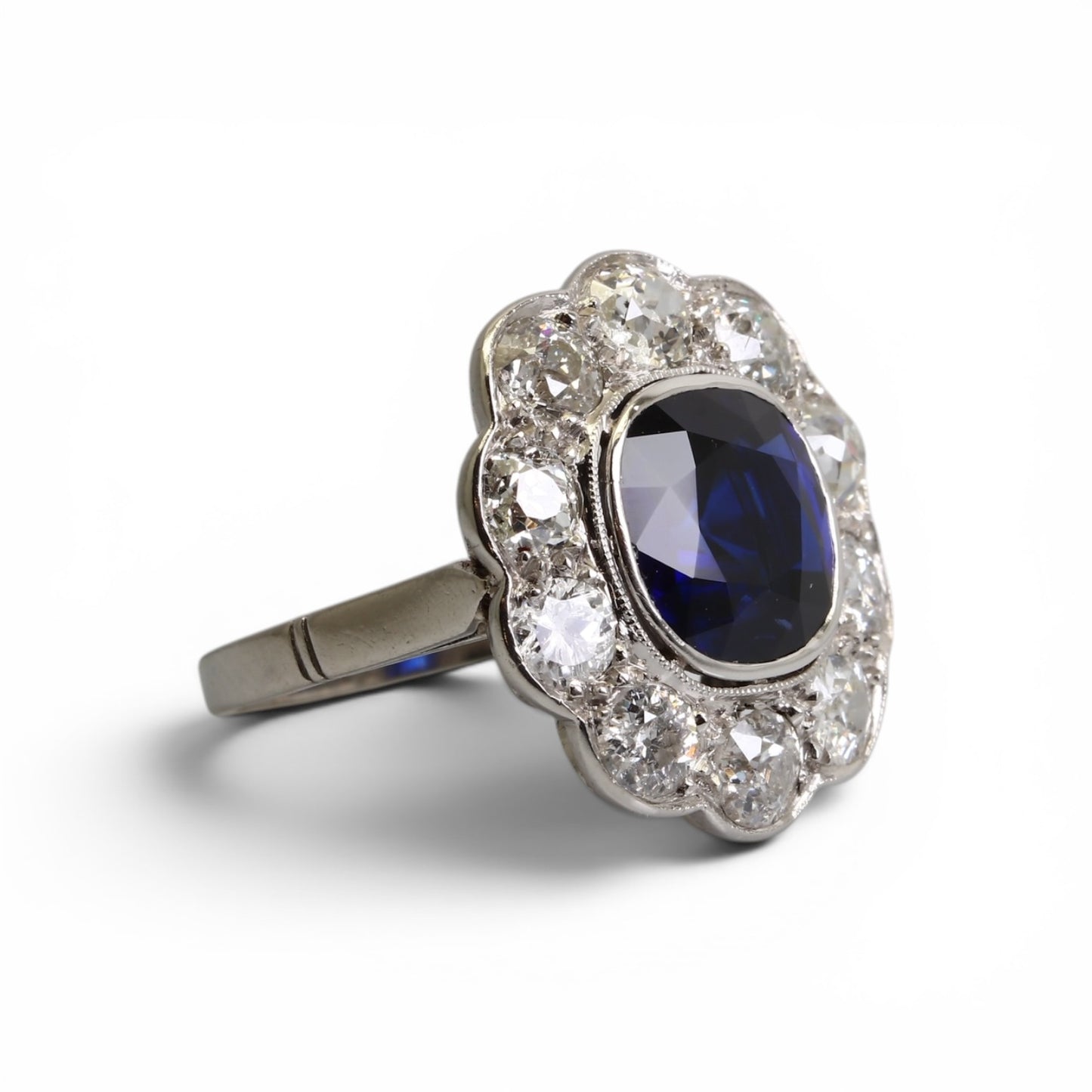 Bague « Marguerite » en platine ornée d’un saphir entouré de diamants taille ancienne.