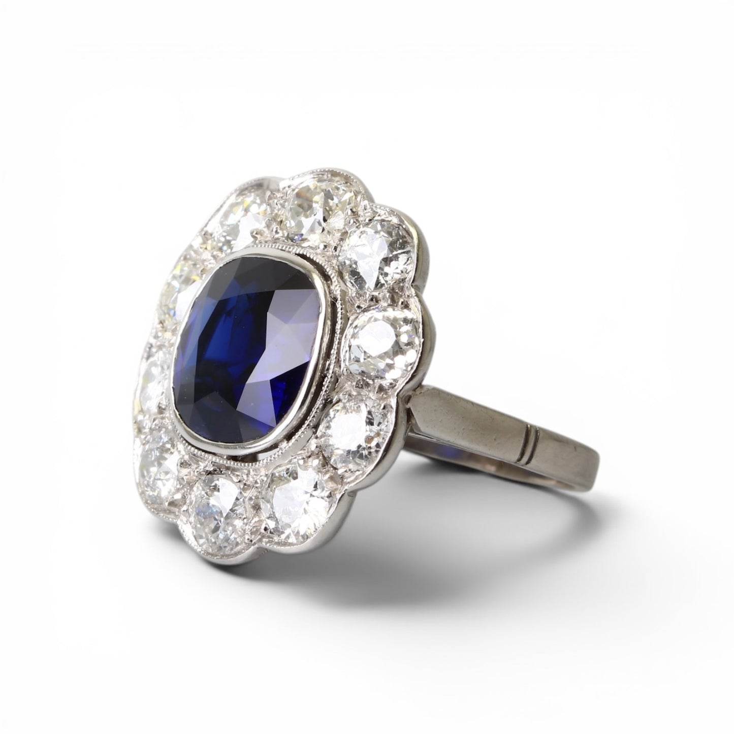 Bague « Marguerite » en platine ornée d’un saphir entouré de diamants taille ancienne.